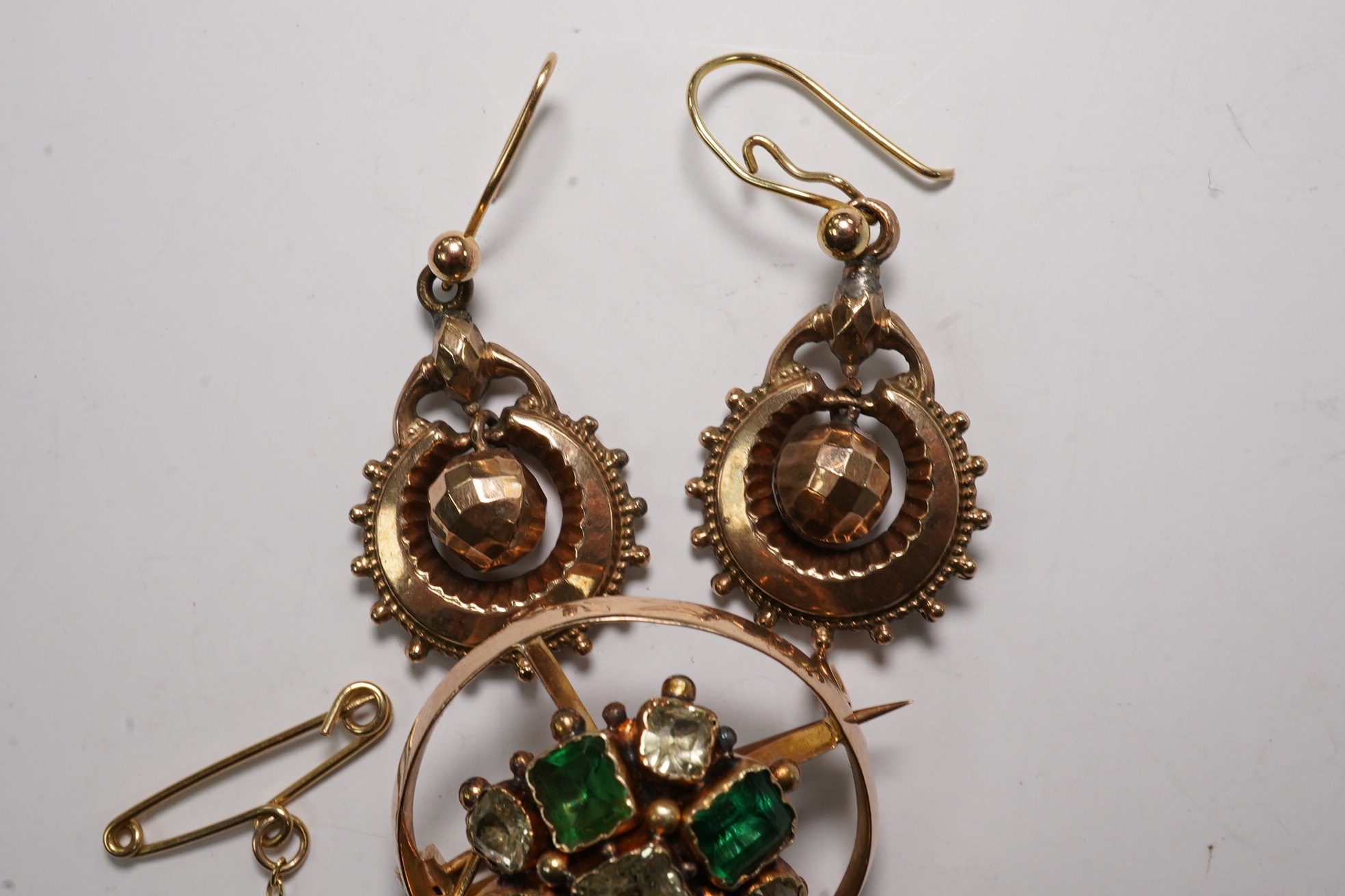 A pair of antique yellow metal drop earrings, 22mm and a yellow metal and two colour green gem set brooch. Condition - poor to fair